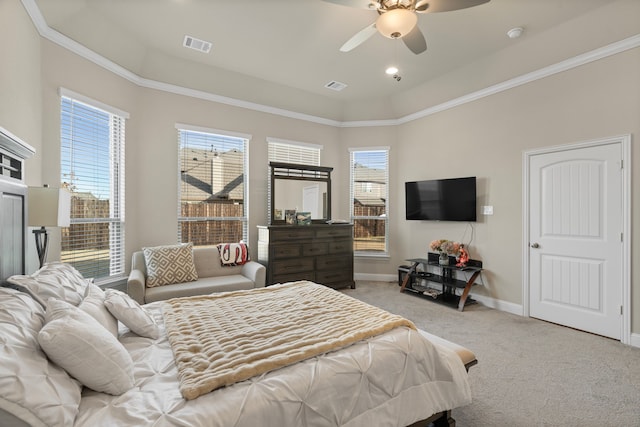 bedroom with ceiling fan, a raised ceiling, light carpet, and multiple windows