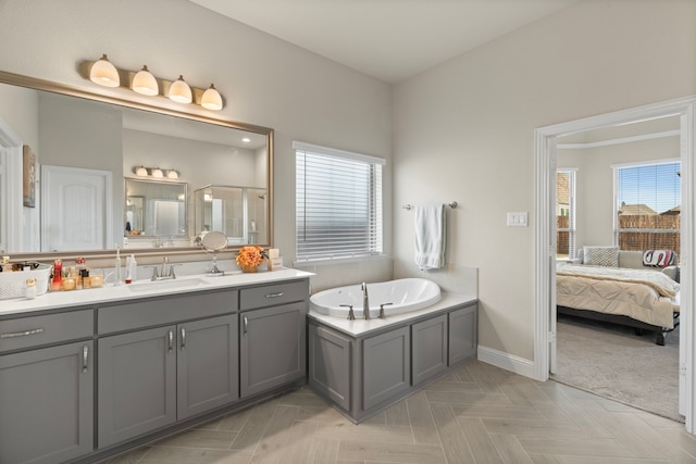 bathroom featuring a tub to relax in, vanity, parquet floors, and a healthy amount of sunlight