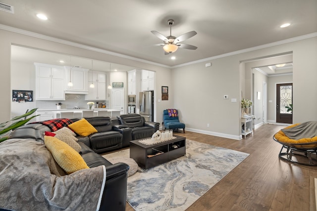 living room featuring ceiling fan, hardwood / wood-style flooring, and crown molding