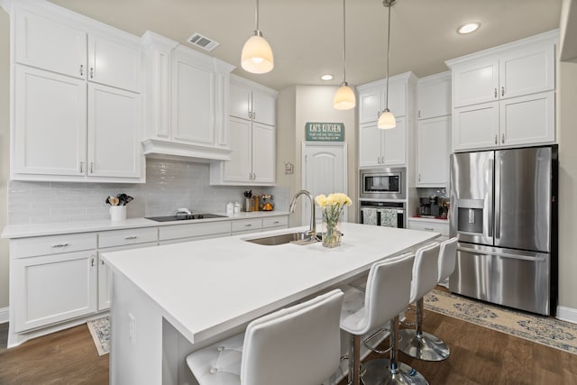 kitchen featuring sink, a center island with sink, white cabinets, and appliances with stainless steel finishes