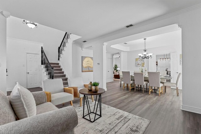 dining room with dark wood-type flooring, a raised ceiling, and an inviting chandelier