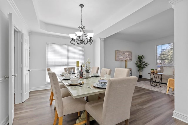 dining room with hardwood / wood-style flooring, a chandelier, and a raised ceiling