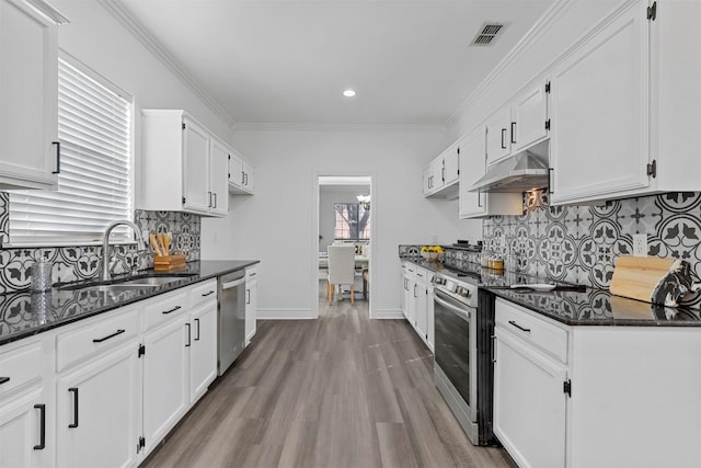 kitchen featuring white cabinetry, stainless steel appliances, sink, and dark stone countertops