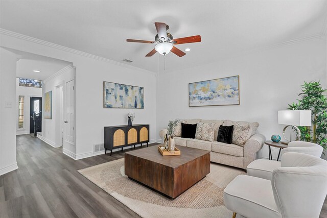 living room with dark wood-type flooring and crown molding