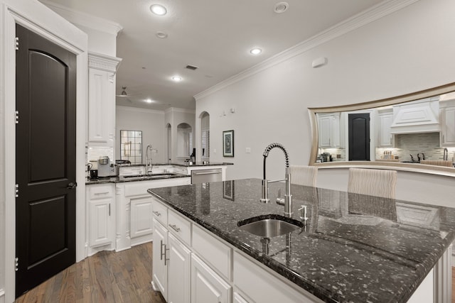 kitchen with white cabinets, sink, and a large island