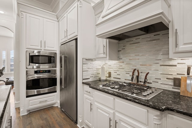 kitchen with stainless steel dishwasher, dark stone countertops, and white cabinetry