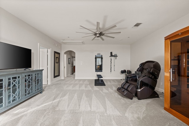 exercise room featuring ceiling fan and light colored carpet