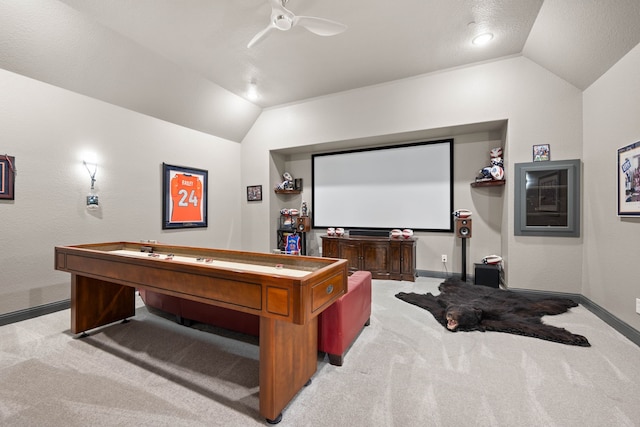 cinema with ceiling fan, vaulted ceiling, and light carpet