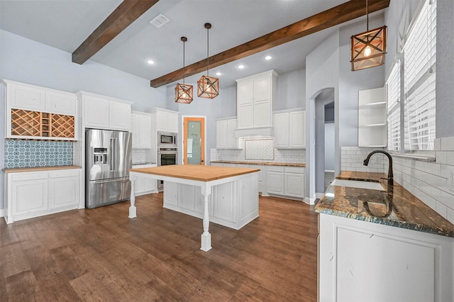 kitchen with white cabinets, sink, stainless steel appliances, and a kitchen island