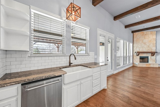 kitchen with white cabinetry, hanging light fixtures, stainless steel dishwasher, and a fireplace