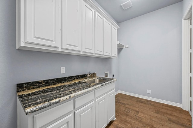 laundry area featuring dark hardwood / wood-style flooring, sink, hookup for a washing machine, and cabinets