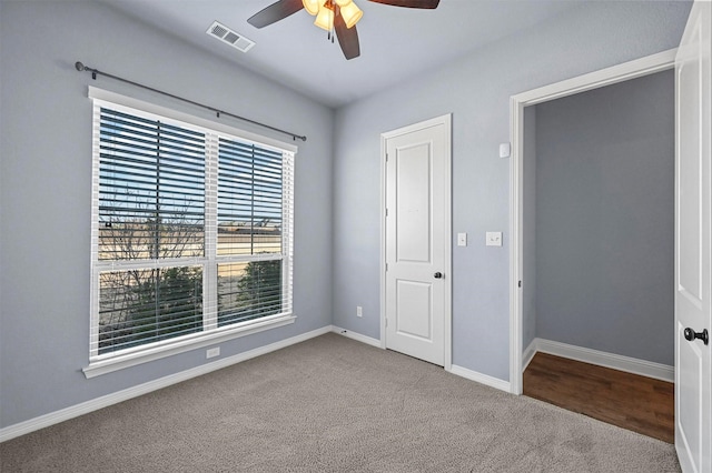 carpeted spare room featuring ceiling fan