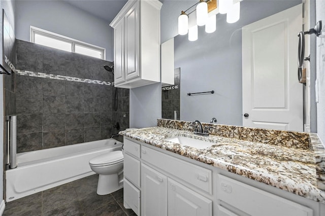 full bathroom featuring tiled shower / bath combo, vanity, and toilet