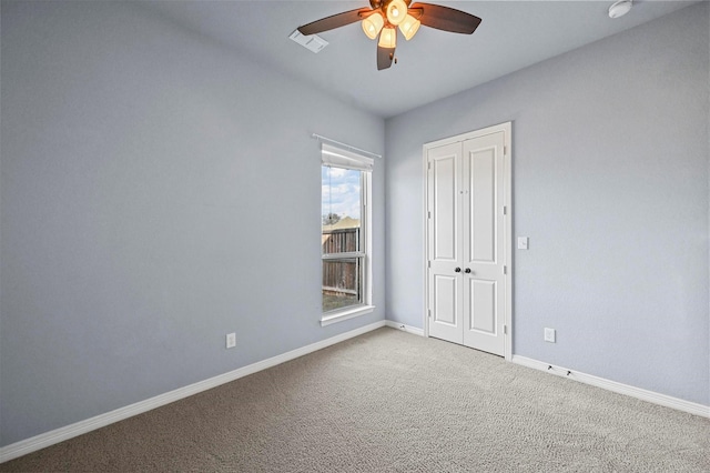 carpeted empty room featuring ceiling fan