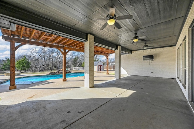 view of patio with ceiling fan and a storage unit