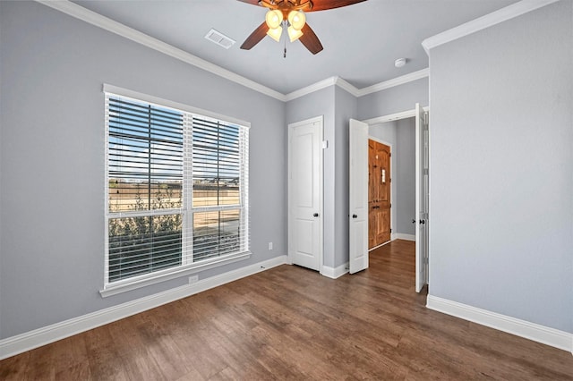 spare room featuring ceiling fan, dark wood-type flooring, and ornamental molding