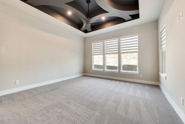 carpeted empty room featuring a tray ceiling