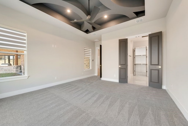 unfurnished bedroom with a towering ceiling, ceiling fan, and light colored carpet