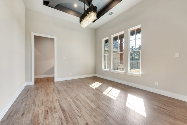 unfurnished dining area featuring an inviting chandelier and light hardwood / wood-style floors