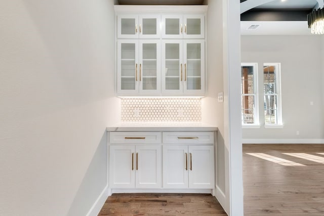 interior space with white cabinets, dark hardwood / wood-style floors, and decorative backsplash