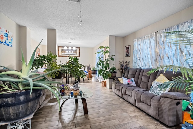 living room featuring a textured ceiling and a chandelier