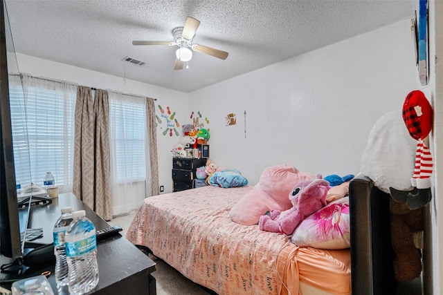 carpeted bedroom featuring a textured ceiling and ceiling fan