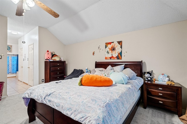 bedroom with lofted ceiling, a textured ceiling, ceiling fan, and light carpet