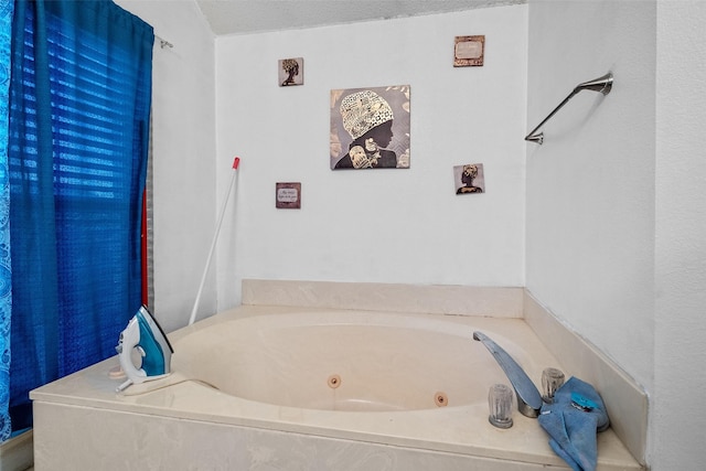 bathroom featuring a tub and a textured ceiling