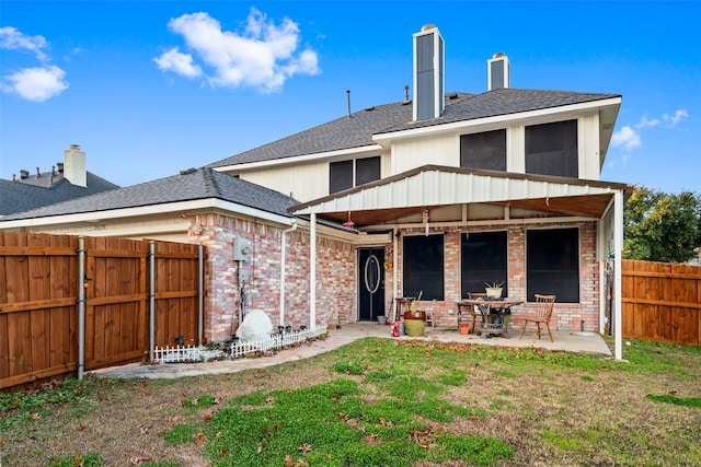 rear view of property with a yard and a patio area