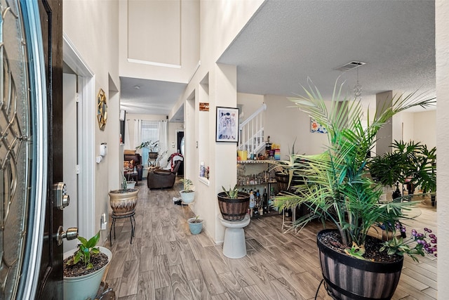 foyer entrance featuring a textured ceiling and light hardwood / wood-style floors