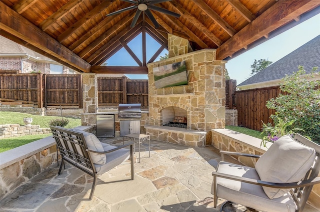 view of patio / terrace featuring a gazebo, area for grilling, ceiling fan, and an outdoor stone fireplace