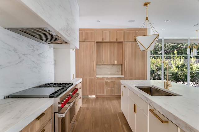 kitchen with light stone countertops, range with two ovens, pendant lighting, tasteful backsplash, and custom range hood