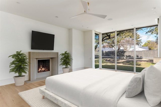 bedroom with ceiling fan, light hardwood / wood-style flooring, and floor to ceiling windows