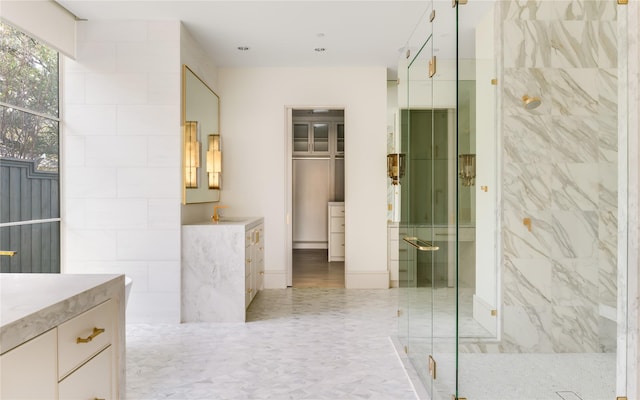 bathroom with tile walls, an enclosed shower, and vanity