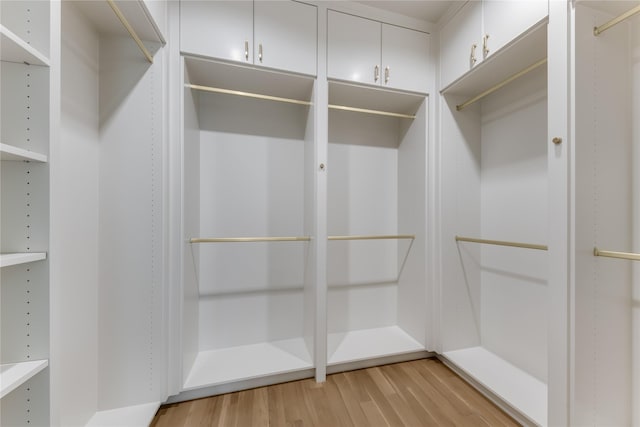 walk in closet with light hardwood / wood-style flooring