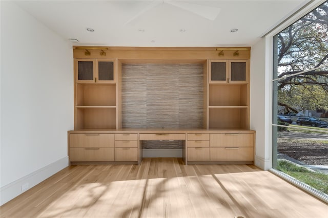 interior space featuring built in desk, light hardwood / wood-style floors, and a wealth of natural light