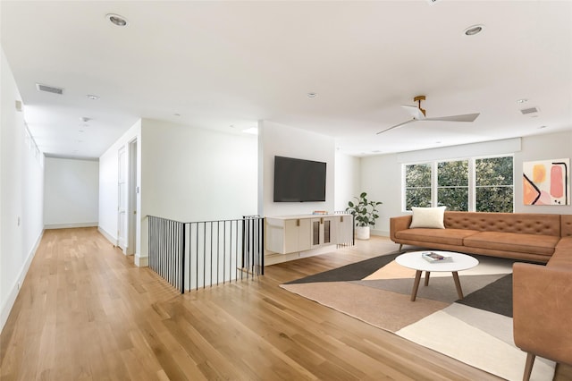 living room with ceiling fan and light hardwood / wood-style flooring