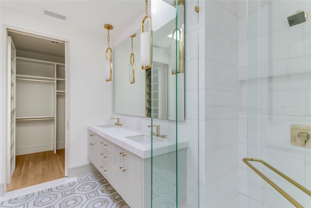 bathroom with a shower with shower door and vanity