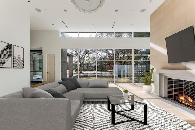 living room featuring a high ceiling and a tile fireplace