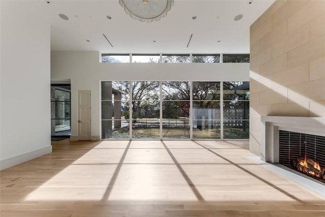 interior space featuring a high ceiling, a fireplace, and wood-type flooring