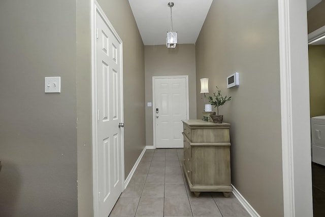 doorway featuring washer / dryer and light tile patterned flooring