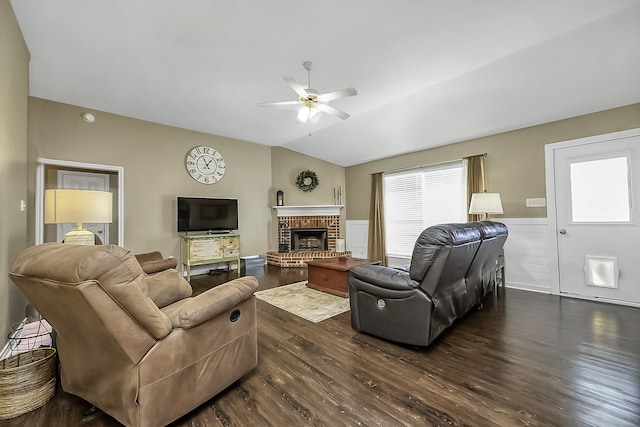 living room with lofted ceiling, dark hardwood / wood-style flooring, a brick fireplace, and ceiling fan