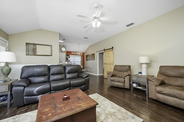 living room featuring ceiling fan, dark hardwood / wood-style flooring, vaulted ceiling, and a barn door