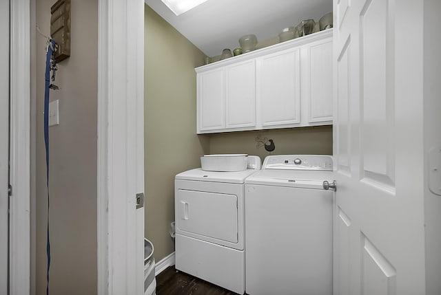 clothes washing area featuring dark wood-type flooring, cabinets, and washer and clothes dryer