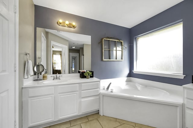 bathroom with a washtub, tile patterned floors, and vanity