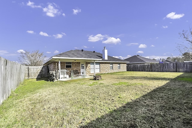 rear view of property with ceiling fan and a lawn