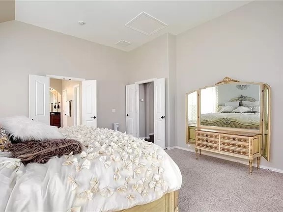 bedroom featuring high vaulted ceiling and carpet