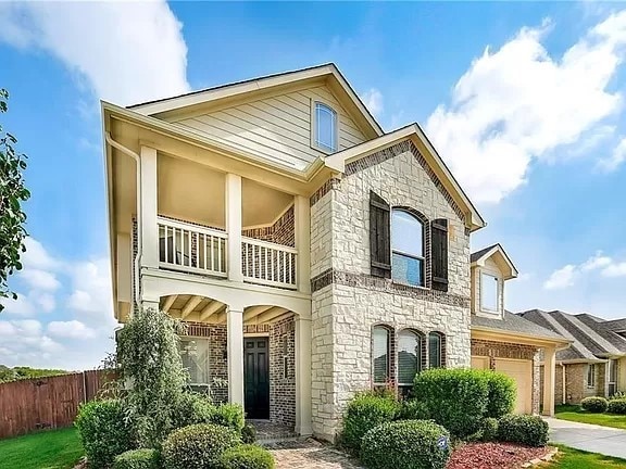 view of front of home with a balcony and a garage