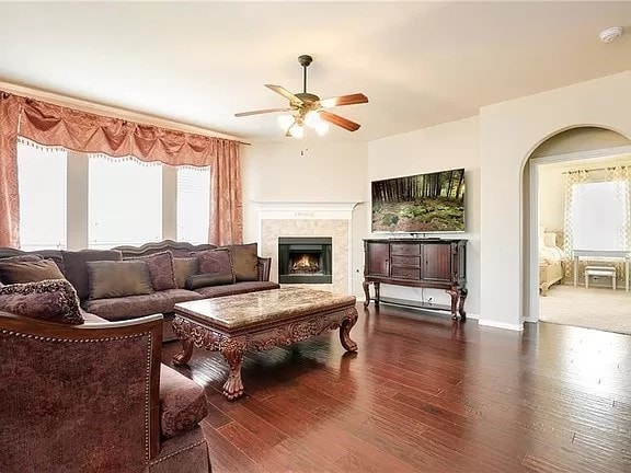 living room with ceiling fan and dark wood-type flooring