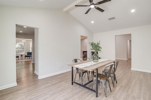 dining space featuring ceiling fan, light hardwood / wood-style floors, and lofted ceiling with beams